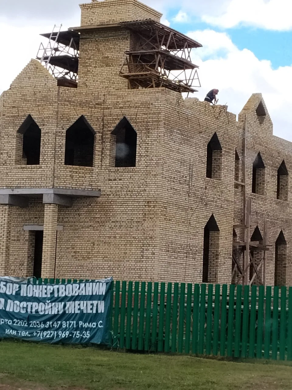 Кладка стен мечети завершена полностью, наверху работает кровельщик, установлены леса под основание минарета